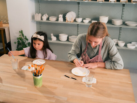 Mother and Daughter Create Pottery Together in a Studio