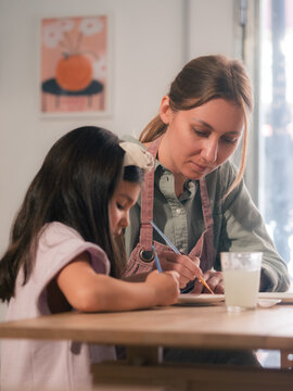 Child and Parent Drawing Together in a Bright Space