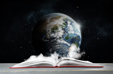Fototapeta premium Open book on table against planet in space