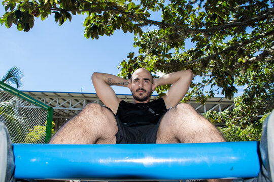 Man Doing abs workout Outdoors in a Park on a Sunny Day