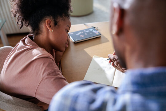 A father and daughter share a creative learning moment