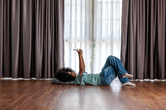 Young girl lying on the floor using a smartphone
