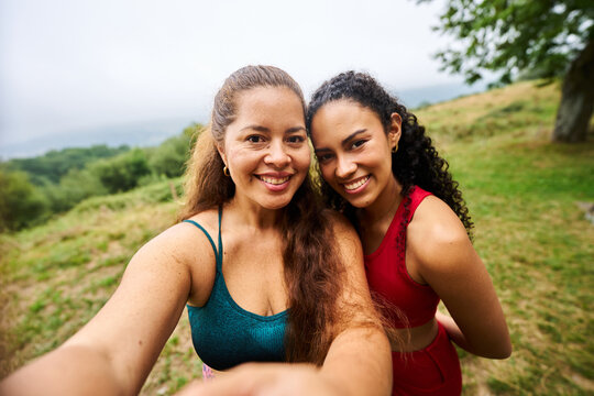 Two happy women taking selfie during outdoor fitness workout