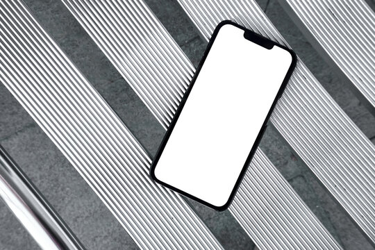 Smartphone with Blank White Screen on Metallic Outdoor Seating Surface
