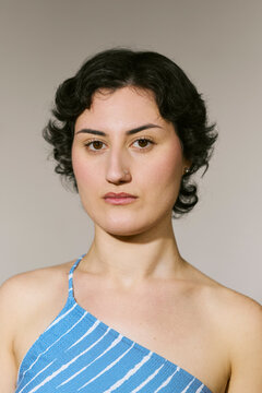 Young Woman with Short Dark Curly Hair in Blue Top