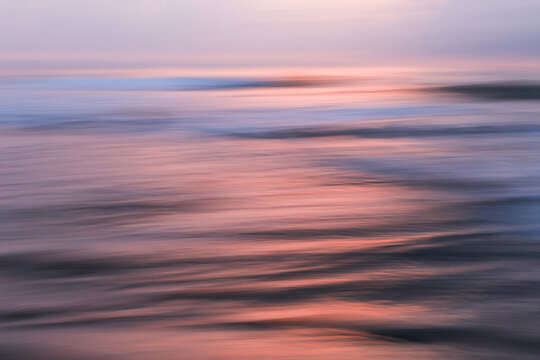 Colorful sunset ocean texture ripples in sunset.