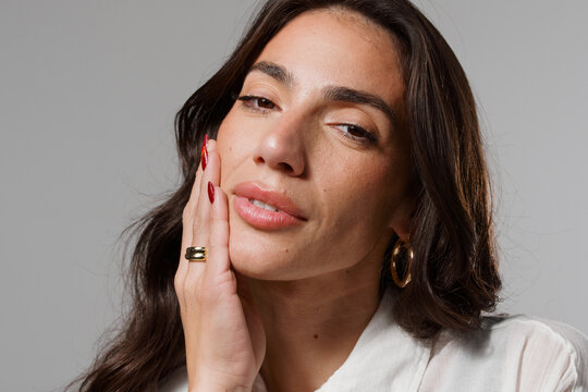 Woman Touching Her Face With a Soft Expression and Long Hair