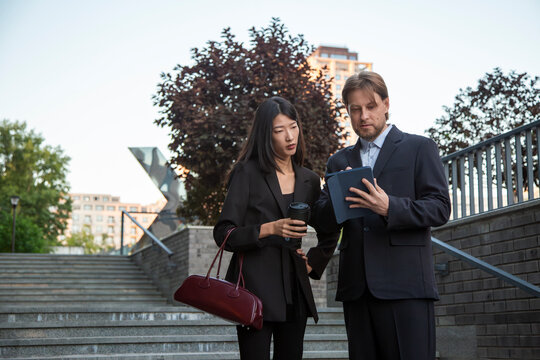 Business colleagues reviewing digital tablet outdoors