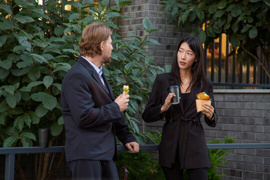 Business colleagues chatting over lunch in urban courtyard