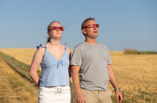 2 people safely viewing the 2026 solar eclipse through special glasses