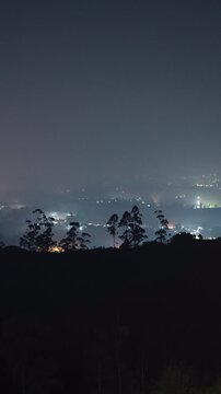 Vertical video - Timelapse of a rural town blanketed by the fog at night