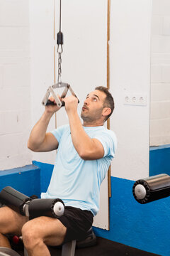 Athletic man performing seated lat pulldown