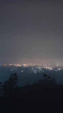Vertical video - Timelapse of a rural town blanketed by the fog at night