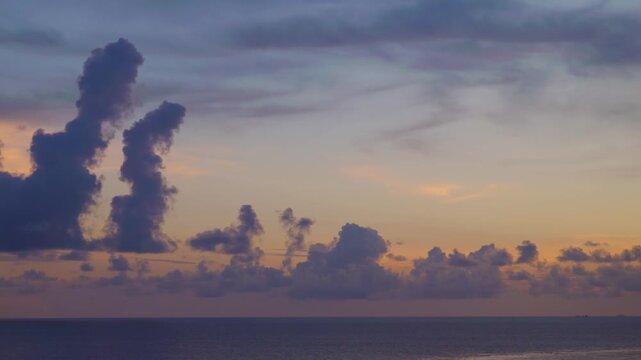 Dramatic Cumulus Clouds Rising Over Calm Ocean Horizon at Sunset 