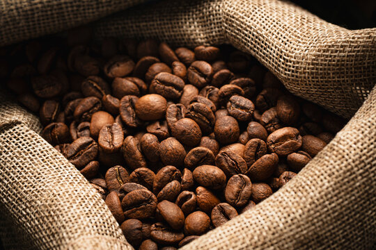Roasted coffee beans spilling from burlap sack