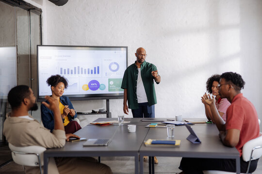 Business Team Meeting With Presenter Showing Data