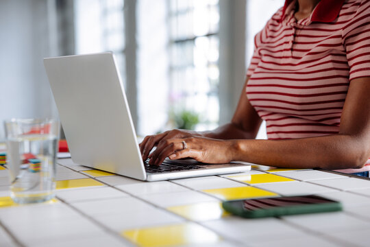 Woman Typing on Laptop at Bright Home Desk