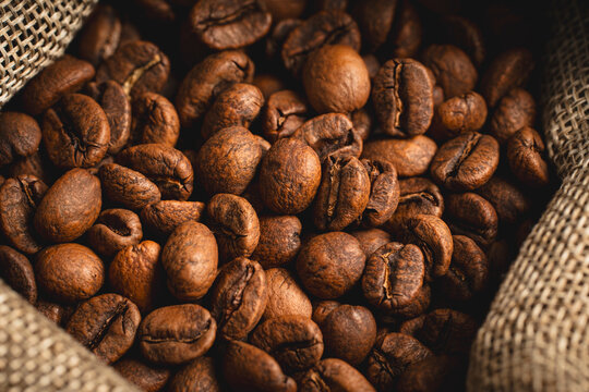 Roasted coffee beans spilling from burlap sack