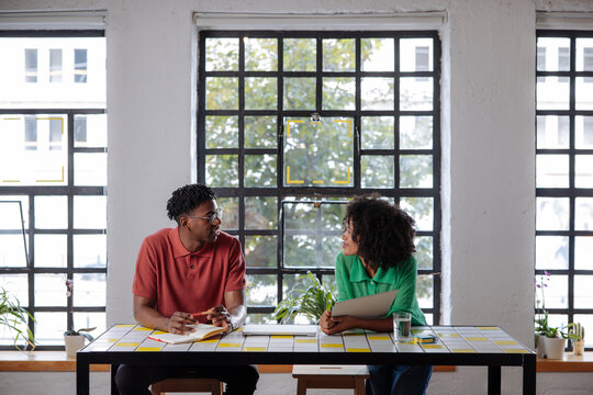 Colleagues Conversing at Casual Office Workspace With Natural Light