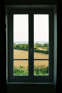 Dark room window looking out to the coastal countryside