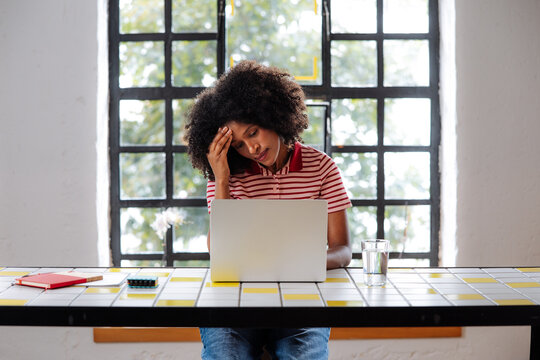 Stressed Woman Working On Laptop At Home Table