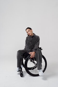 Model Poses in a Wheelchair During a Studio Photoshoot