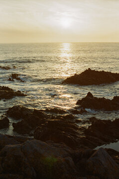 Golden sun setting over a rocky ocean coast