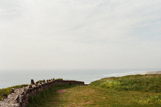 Old stone wall on a grassy cliff overlooking the ocean