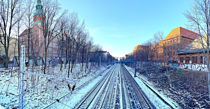 Train tracks in the snow with buildings