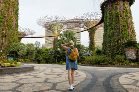 Woman traveler wearing blue dress and hat at Gardens by the Bay in Singapore