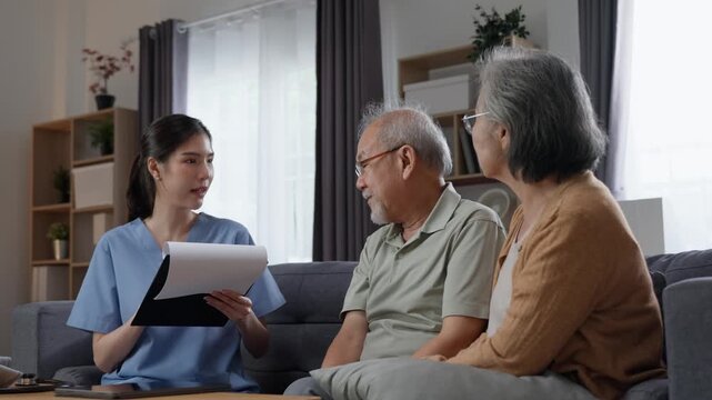 Home nurse documenting health status of senior patients sitting on living room couch