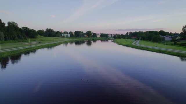 Drone flying over calm lake at dusk in Northern Europe