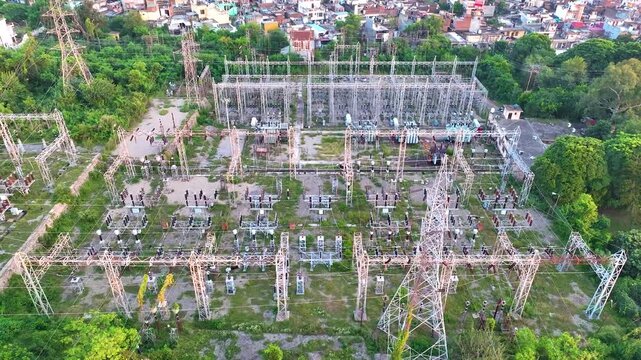 Aerial pullback reveal of a high-voltage electrical substation in India, showcasing massive power grid infrastructure and energy distribution networks.