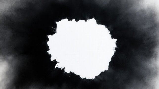 Abstract black spray paint explosion creates a circular frame with a soft textured edge on white. Ideal for artistic backgrounds and design projects.