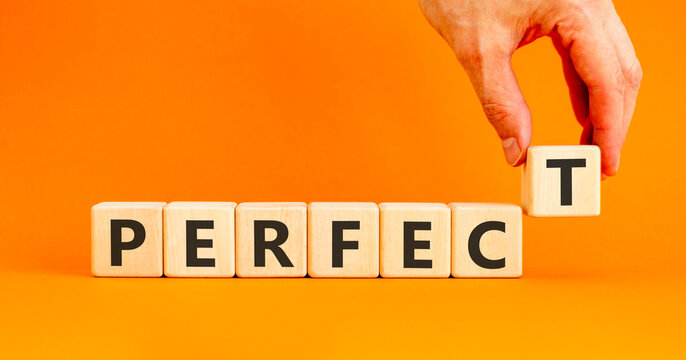 Perfect word symbol. Concept word Perfect on beautiful wooden blocks. Beautiful orange table orange background. Businessman hand. Business perfect word concept. Copy space.