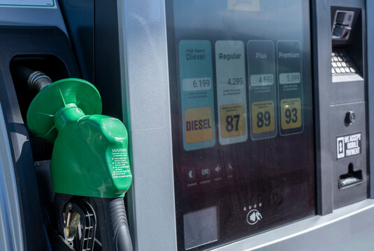 Gas station pump nozzle with fuel prices on digital screen
