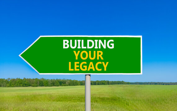 Building your legacy words symbol. Concept words Building your legacy on beautiful green road sign. Beautiful blue sky green grass background. Business building your legacy concept. Copy space.