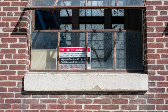 No trespassing sign inside open brick building window