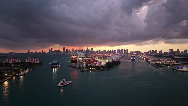 Cityscape illuminated at night. Night cityscape with Miami port with cargo and cruise ship, aerial view. Dramatic aerial view. Miami port. Cargo port with dramatic sky. Port of Miami. 4k footage