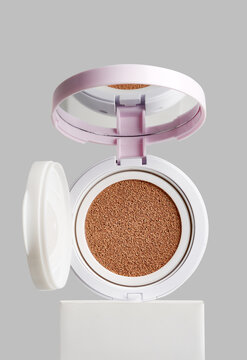 An open compact cushion foundation with beige makeup sponge