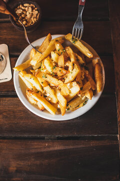 Plato de papas fritas sobre mesa de madera en vista cenital