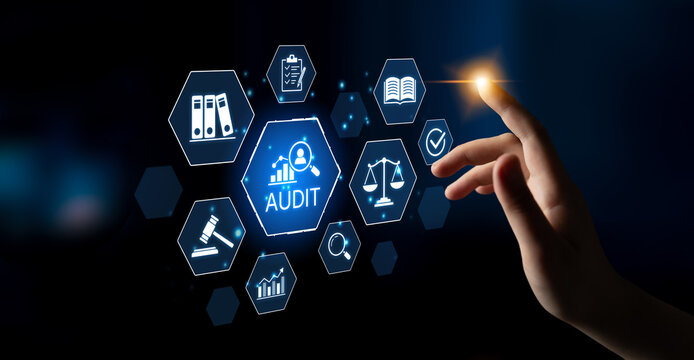 Hand Reaching Towards Digital Audit Icon with Various Business Elements Featuring Scales, Documents, and Checkmarks Against a Dark Background. Bitwise.