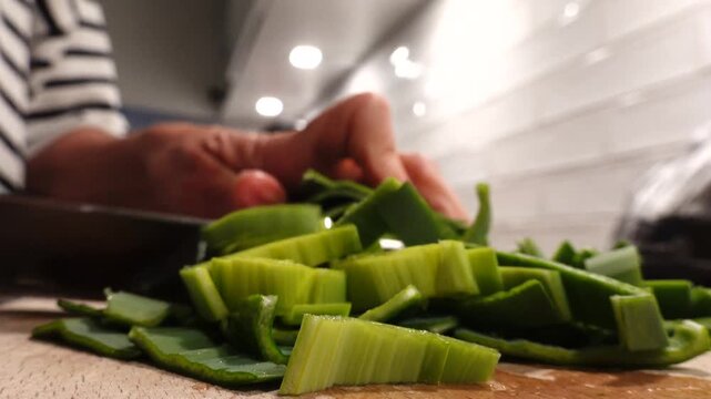 Stockholm, Sweden A cook in a residential kitchen slices fresh green leeks for a soup. 