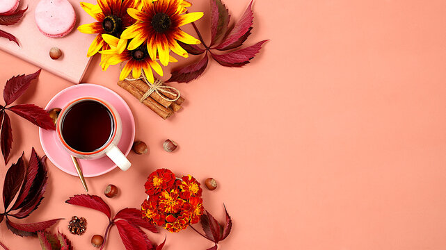 Autumn card with hot tea in a glass cup, nuts and spices on the background of seasonal flowers and leaves, cozy warm concept, hello autumn, hygge style, selective focus, top view, space for text