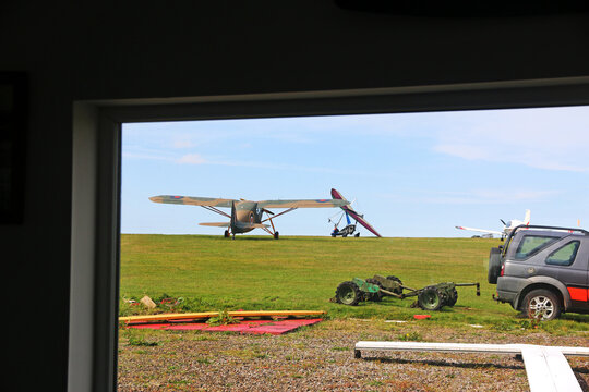 	
Light airplane standing on a grass runway	