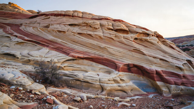 Close up view of the wavy sandstone rock formations in the desert featuring layers of red, orange, and white mineral deposits and textures