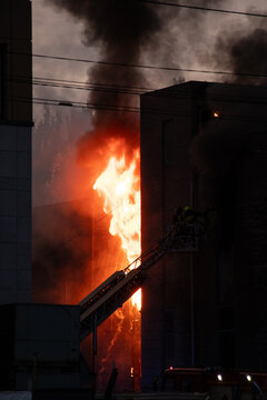 Firefighters put out the burning building of the shopping center. Smoke and fire after a drone attack in Ukraine, rescuers are working at the scene