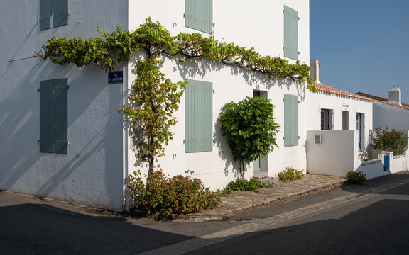 Ruelle pittoresque et maisons blanches traditionnelles aux volets color&eacute;s dans le village de Saint-Sauveur, &Icirc;le d'Yeu, France.