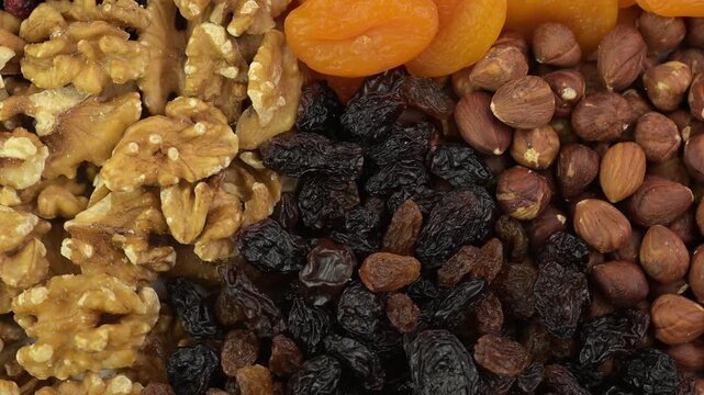 Dried fruits and nuts close-up, top view, rotating 