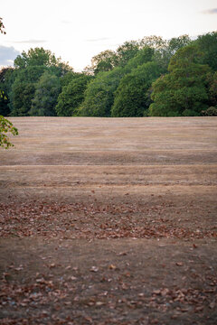 Dry Autumn Field With Scattered Fallen Leaves In Park After Summer Drought in England UK